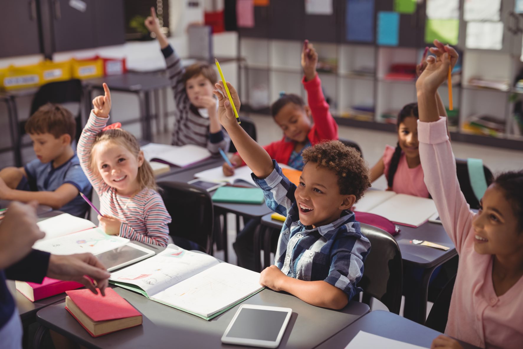 kids in a school with hands up