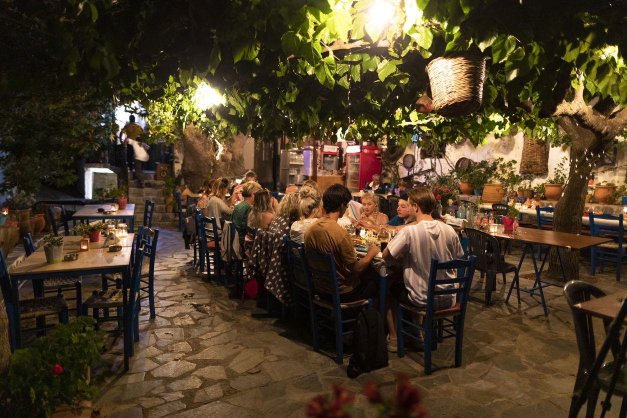 Group of friends eating dinner in Mediterranean courtyard