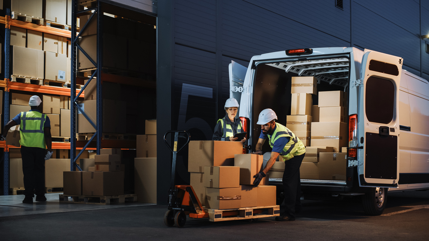 Outside of Logistics Retail Warehouse With Inventory Manager Using Tablet Computer, talking to Worker Loading Delivery Truck with Cardboard Boxes, Online Orders, Food and Medicine Supply, E-Commerce