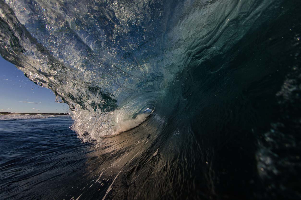 Surfers view looking into a blue barrelling wave